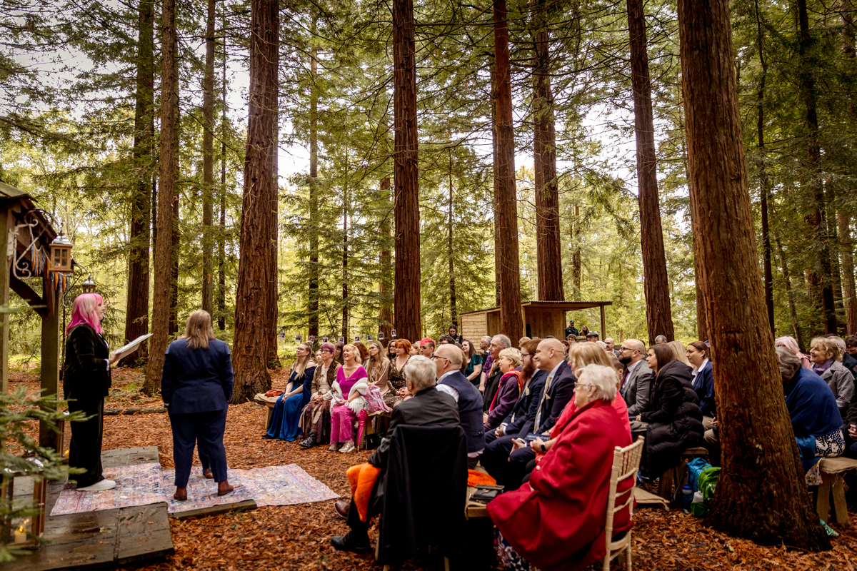 intergenerational wedding ceremony in a woodland for poly couple Wedding ceremony in a woodland. People of all ages are engaged with the ceremony