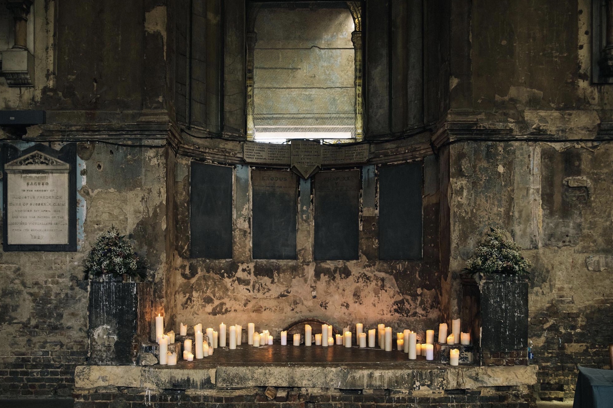 A beautiful collection of lit candles in a gothic space.
