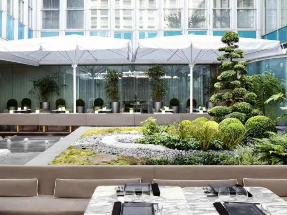 The Sanderson London Accessible unusual London Wedding venue A courtyard outside with beautiful japanese topiary trees and large white canopies