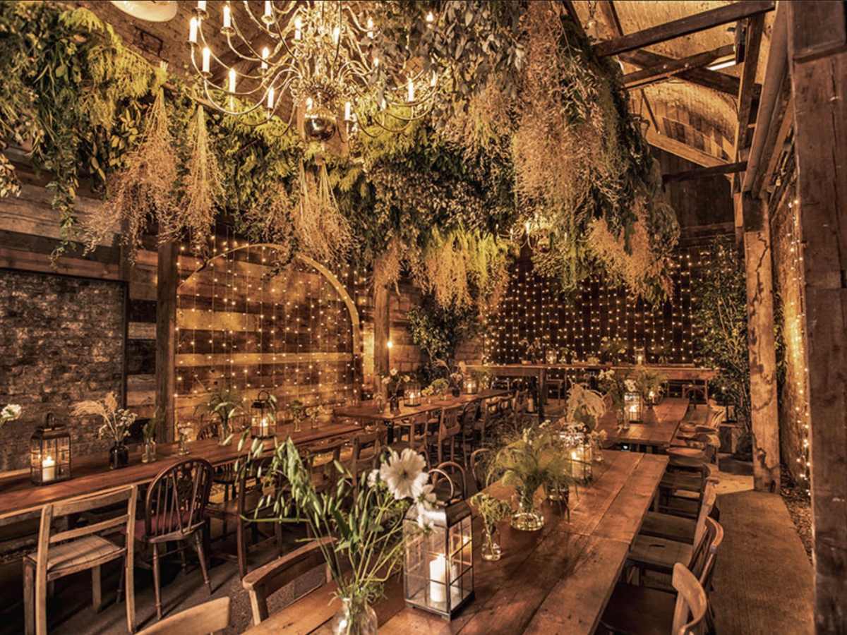 The-timber-store-london-wedding-venue Gorgeous fairy lights and greenery in a starry, golden candlelit wedding space.